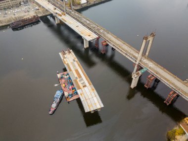 Hava aracı görüntüsü. Kiev 'de Dinyeper nehri üzerinde bir köprü inşa ediliyor. Bulutlu bir sonbahar sabahı.