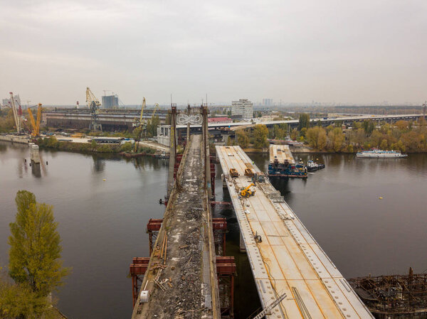 Aerial drone view. Construction of a bridge across the Dnieper river in Kiev. Sunny autumn morning.