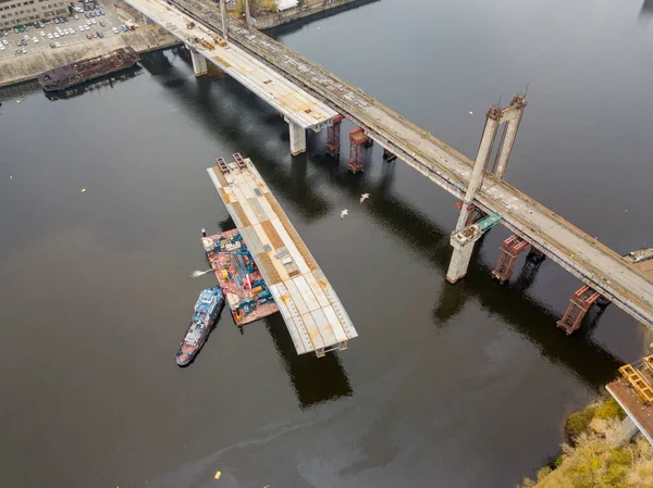 Hava aracı görüntüsü. Kiev 'de Dinyeper nehri üzerinde bir köprü inşa ediliyor. Bulutlu bir sonbahar sabahı.