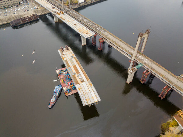 Aerial drone view. Construction of a bridge across the Dnieper river in Kiev. Cloudy autumn morning.