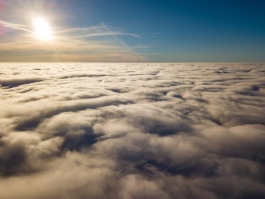 Kıvırcık bulutların üzerinde uçan hava. Güneşin ışınları bulutların üzerinde parlıyor.