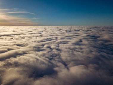 Kıvırcık bulutların üzerinde uçan hava. Güneşin ışınları bulutların üzerinde parlıyor.