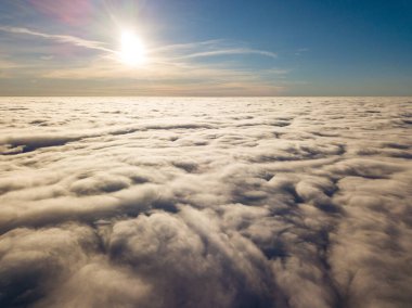 Kıvırcık bulutların üzerinde uçan hava. Güneşin ışınları bulutların üzerinde parlıyor.