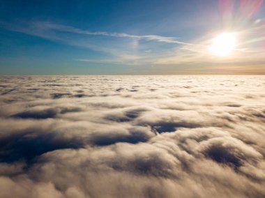 Kıvırcık bulutların üzerinde uçan hava. Güneşin ışınları bulutların üzerinde parlıyor.