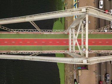Hava aracı görüntüsü. Kiev 'deki Dinyeper Nehri üzerinde bir yaya ve bisiklet köprüsü. Köprüde kırmızı bisiklet yolu.