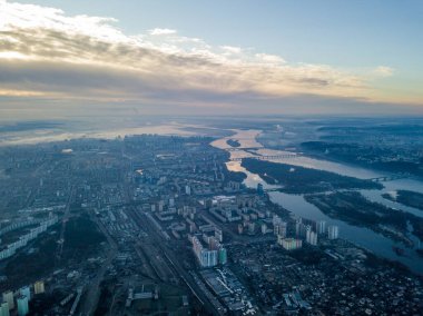 Kiev üzerinde havadan yüksek uçuş, şehrin üzerinde sis bulutu. Sonbahar sabahı, Dinyeper Nehri ufukta görünüyor..
