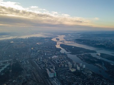 Kiev üzerinde havadan yüksek uçuş, şehrin üzerinde sis bulutu. Sonbahar sabahı, Dinyeper Nehri ufukta görünüyor..