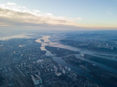 Kiev üzerinde havadan yüksek uçuş, şehrin üzerinde sis bulutu. Sonbahar sabahı, Dinyeper Nehri ufukta görünüyor..