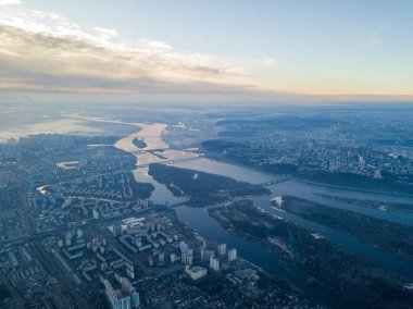 Kiev üzerinde havadan yüksek uçuş, şehrin üzerinde sis bulutu. Sonbahar sabahı, Dinyeper Nehri ufukta görünüyor..