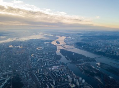 Kiev üzerinde havadan yüksek uçuş, şehrin üzerinde sis bulutu. Sonbahar sabahı, Dinyeper Nehri ufukta görünüyor..