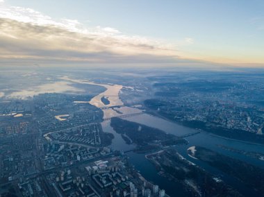 Kiev üzerinde havadan yüksek uçuş, şehrin üzerinde sis bulutu. Sonbahar sabahı, Dinyeper Nehri ufukta görünüyor..