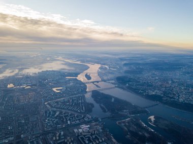 Kiev üzerinde havadan yüksek uçuş, şehrin üzerinde sis bulutu. Sonbahar sabahı, Dinyeper Nehri ufukta görünüyor..