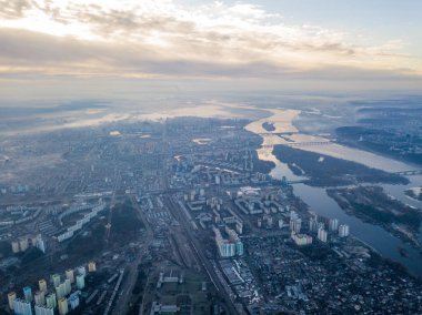 Kiev üzerinde havadan yüksek uçuş, şehrin üzerinde sis bulutu. Sonbahar sabahı, Dinyeper Nehri ufukta görünüyor..
