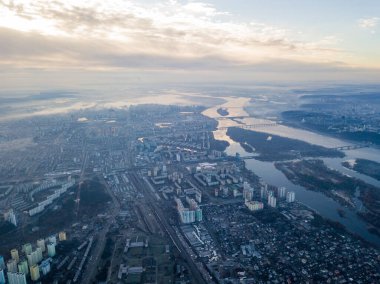 Kiev üzerinde havadan yüksek uçuş, şehrin üzerinde sis bulutu. Sonbahar sabahı, Dinyeper Nehri ufukta görünüyor..