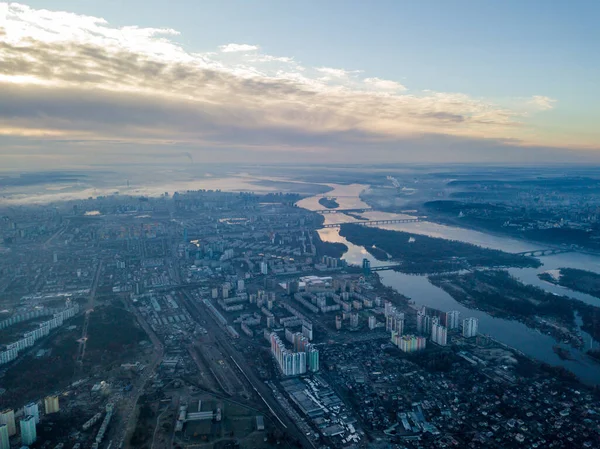 Kiev üzerinde havadan yüksek uçuş, şehrin üzerinde sis bulutu. Sonbahar sabahı, Dinyeper Nehri ufukta görünüyor..