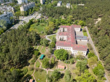 Hava aracı görüntüsü. Güneşli bir yaz gününde şehrin varoşlarındaki binalar.