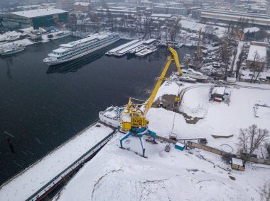 Karlı bir limanda kargo vinci. Kar fırtınası, kar fırtınası. Hava aracı görünümü.