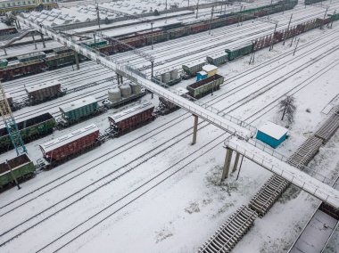 İstasyondaki karla kaplı yük treni. Kar fırtınası, kar fırtınası. Hava aracı görünümü.