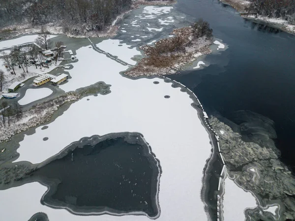 Aerial drone top view. Frosty pattern drawing on the river. Cloudy frosty winter morning.