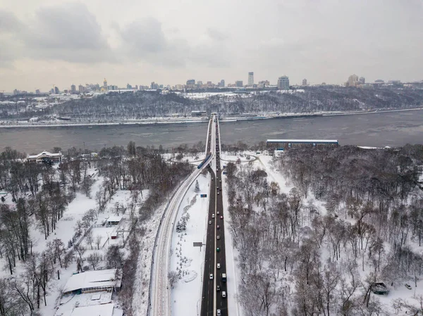 Snow-covered metro bridge in Kiev. Cloudy winter morning. Aerial drone view.