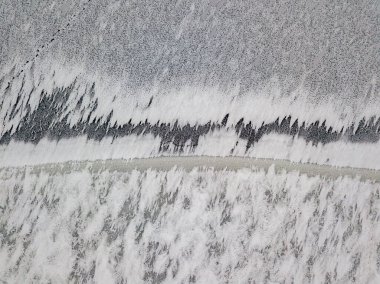 Hava aracı üst görüntüsü. Nehirde donma izleri var. Bulutlu, dondurucu kış sabahı.