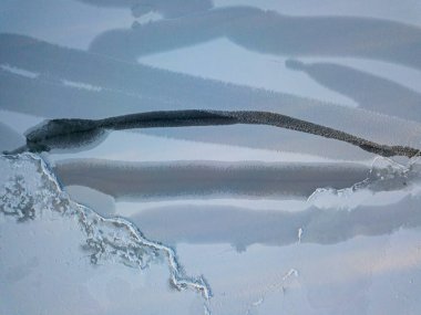 Hava aracı üst görüntüsü. Nehirde donma izleri var. Güneşli, soğuk kış sabahı.