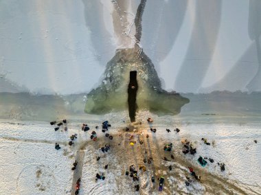 Hava aracı görüntüsü. Epifani nehirdeki bir buz deliğinde yüzüyor. Güneşli, soğuk kış sabahı.