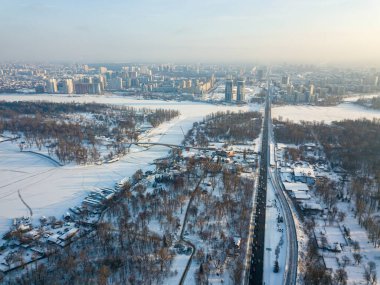 Kiev 'in karla kaplı sol kıyısı. Hava aracı görüntüsü. Kış güneşli, soğuk bir sabah.