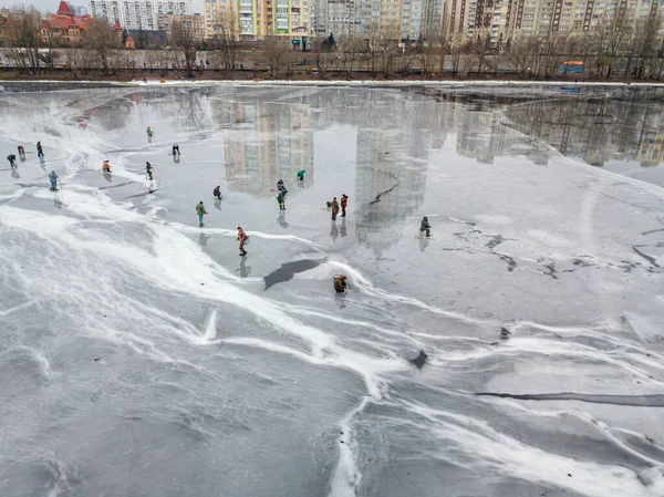 Fishermen on thin ice. Frosty drawing on ice. Aerial drone view. Winter cloudy morning.