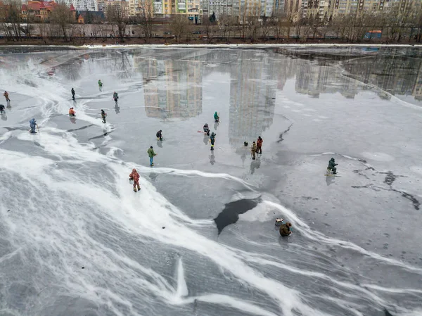 Fishermen on thin ice. Frosty drawing on ice. Aerial drone view. Winter cloudy morning.