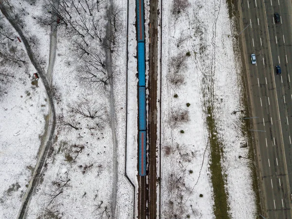 Kiev metro line in a snowy park. Aerial drone view. Winter snowy morning.