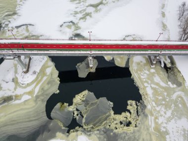 Kiev 'deki Dinyeper Nehri üzerindeki yaya köprüsü. Nehirde kar izleri var. Hava aracı görüntüsü. Kış karlı sabah.