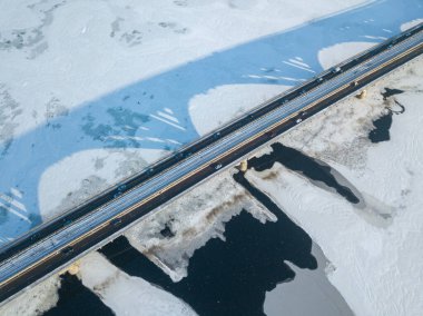 Kyiv metro köprüsü. Donmuş Dnipro nehrine bir gölge düşüyor. Hava aracı görüntüsü. Kış güneşli sabah.