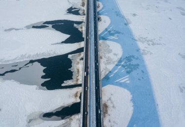 Kyiv metro köprüsü. Donmuş Dnipro nehrine bir gölge düşüyor. Hava aracı görüntüsü. Kış güneşli sabah.