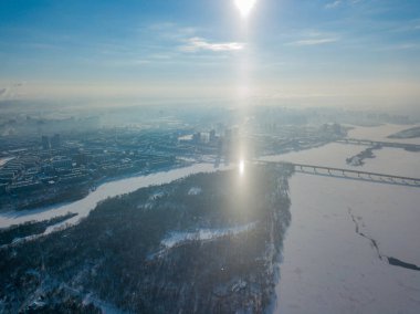 Kiev 'deki Dinyeper nehrinin üzerindeki güneşten gelen ışık sütunu. Hava aracı görüntüsü. Kış güneşli sabah.