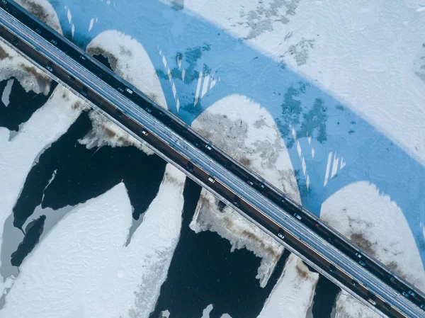 Kyiv metro bridge. A shadow falls on the frozen Dnipro river. Aerial drone view. Winter sunny morning.