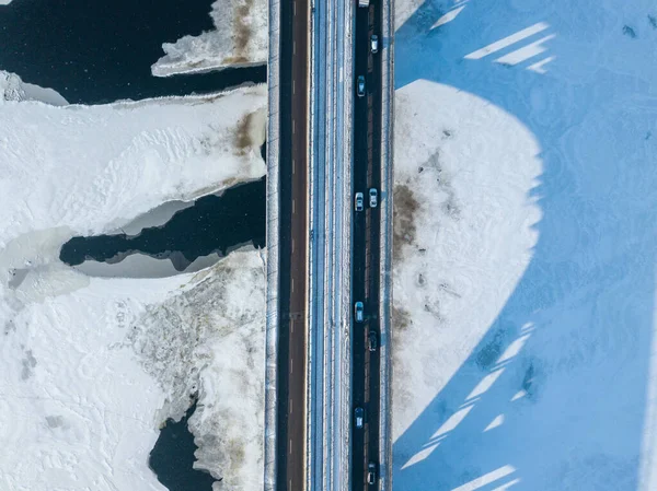 Kyiv metro bridge. A shadow falls on the frozen Dnipro river. Aerial drone view. Winter sunny morning.