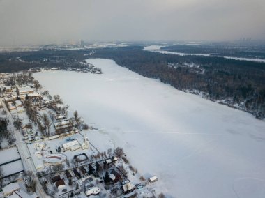 Kiev 'deki donmuş Dinyeper nehri. Hava aracı görüntüsü. Kış dondurucu bir sabah. Güneş bulutların arasından doğar.