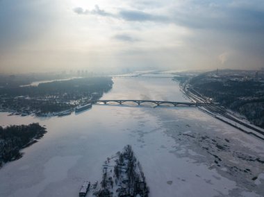 Kiev 'deki donmuş Dinyeper nehri. Hava aracı görüntüsü. Kış dondurucu bir sabah. Güneş bulutların arasından doğar.