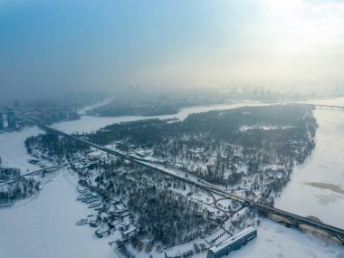 Kiev 'deki Dinyeper Nehri' ndeki ada. Hava aracı görüntüsü. Kış dondurucu bir sabah. Güneş bulutların arasından doğar.