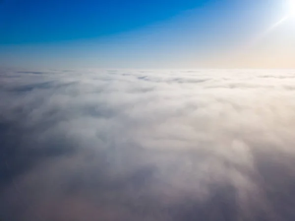 Flight high above the clouds. Aerial drone view.
