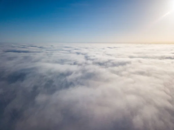 Flight high above the clouds. Aerial drone view.