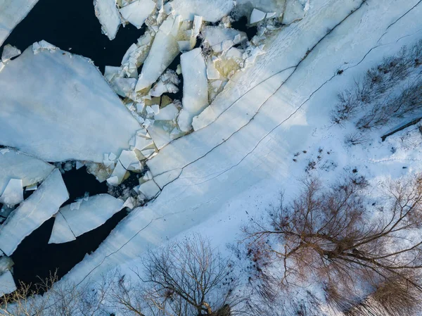 Ice melts on the river. Ice crack. Aerial drone view. Spring sunny morning.