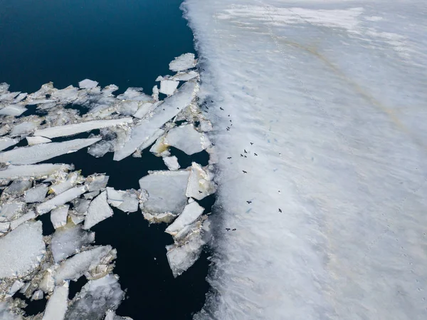 Ice melts on the river. Ice crack. Aerial drone view. Spring sunny morning.