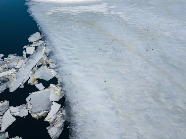 Ice melts on the river. Ice crack. Aerial drone view. Spring sunny morning.