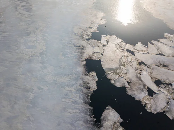 Ice melts on the river. Ice crack. Aerial drone view. Spring sunny morning.