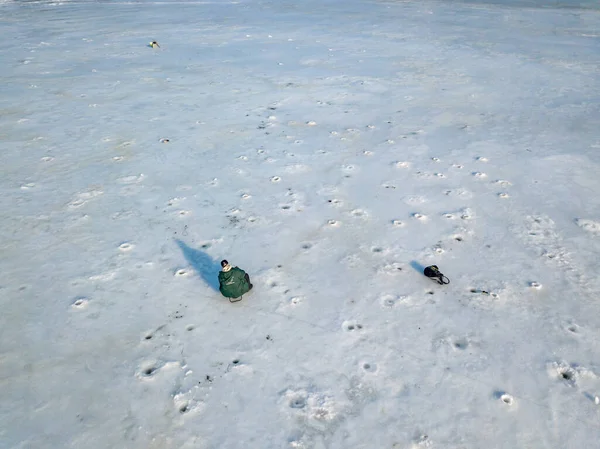 Fisherman on ice. Aerial drone view. Winter sunny morning.