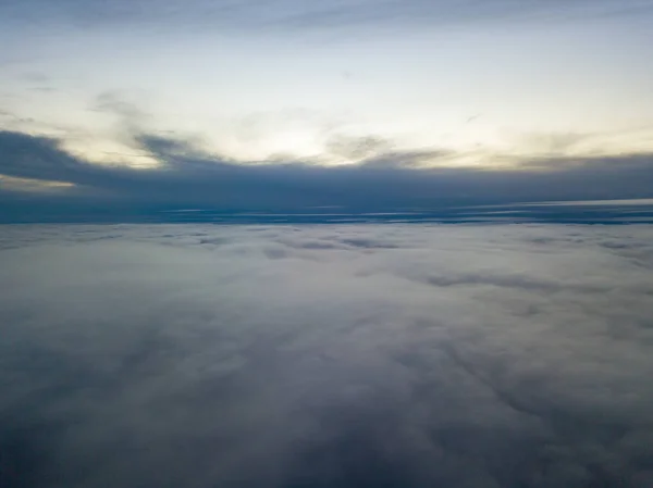 High flight above the clouds at sunset. Aerial view.