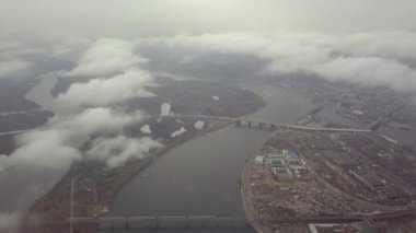 Kiev üzerinde bulutlar yükseliyor. Bulutların arasında kar yağıyor, nehrin ve şehrin altında..