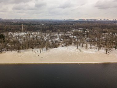 Nehrin kumlu kıyısında hafif kar. Hava aracı görünümü.